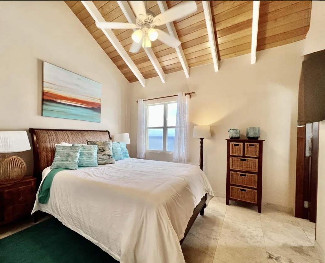 Oceanview bedroom with vaulted ceilings—wake up to blue water and island breezes.