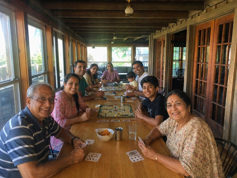 Family playing cards together around a long table