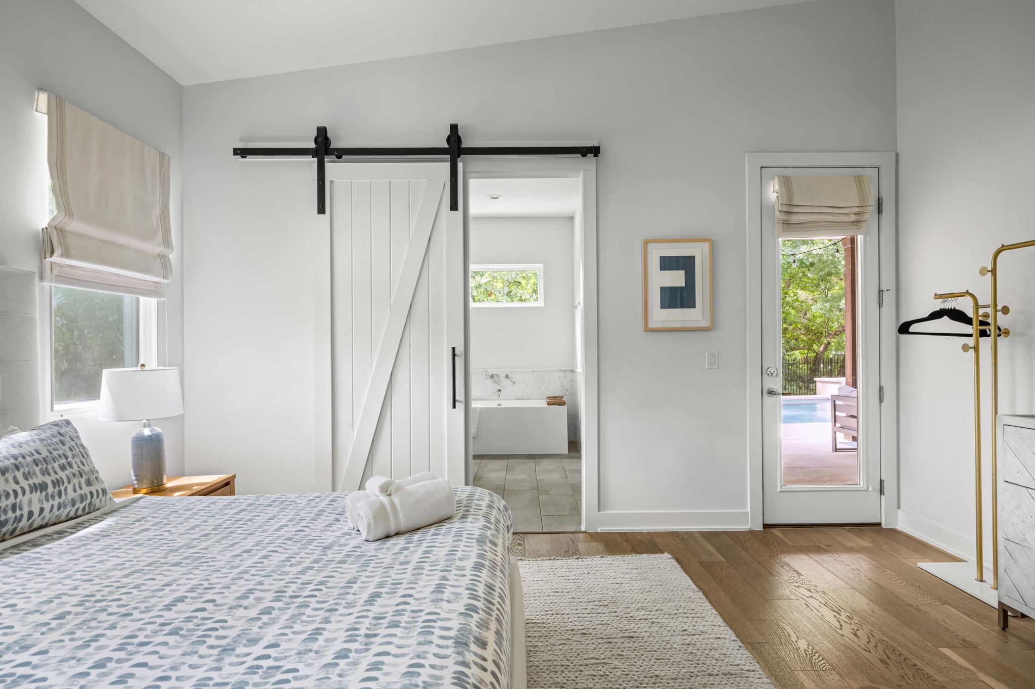 Primary bedroom with direct access to a private bath and outdoor patio doors — bright, airy, and thoughtfully designed.