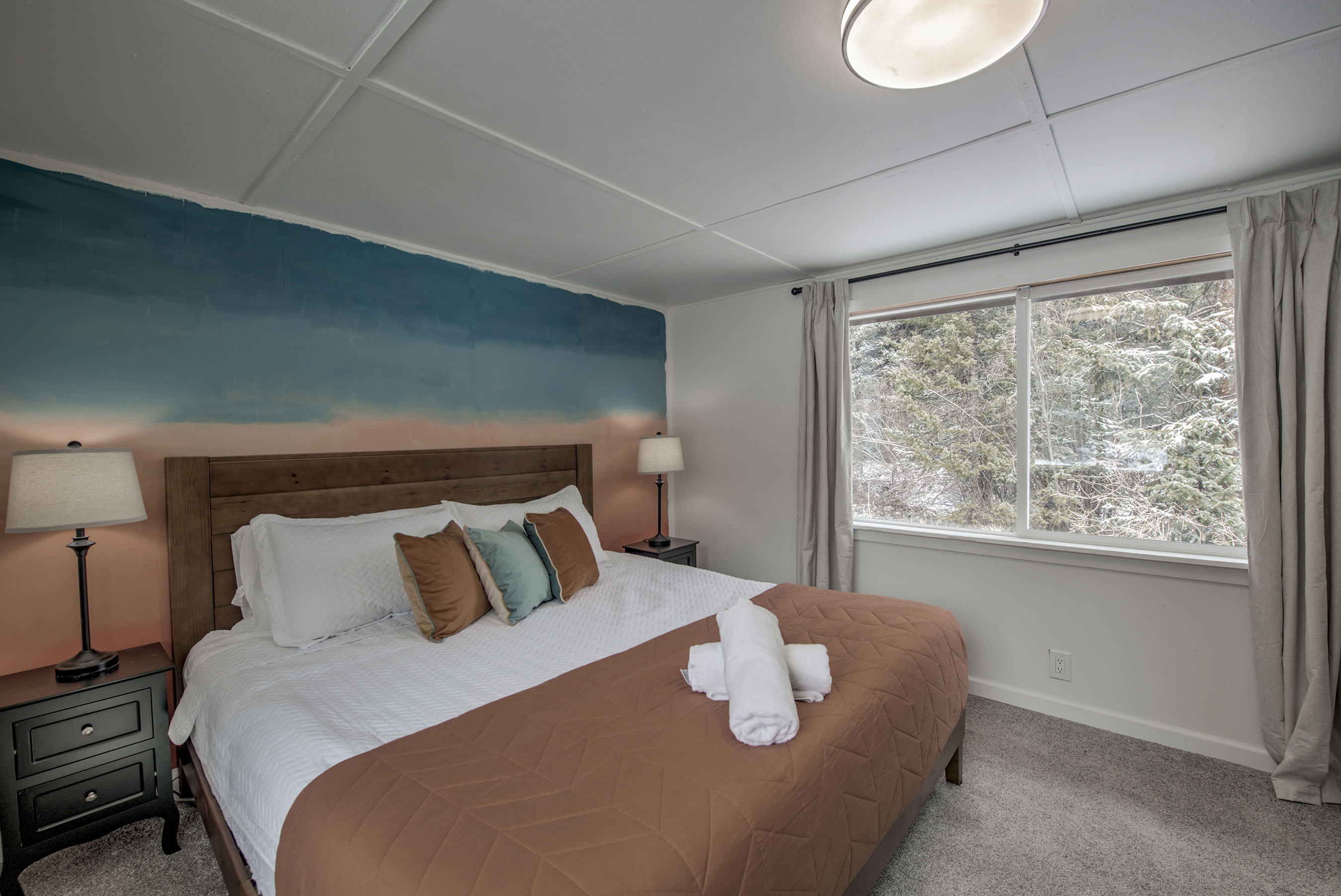 Wake up to peaceful forest views and the sounds of Spruce Creek — your cozy bedroom features soft bedding, warm tones, and a tranquil space that feels yours perfectly. 