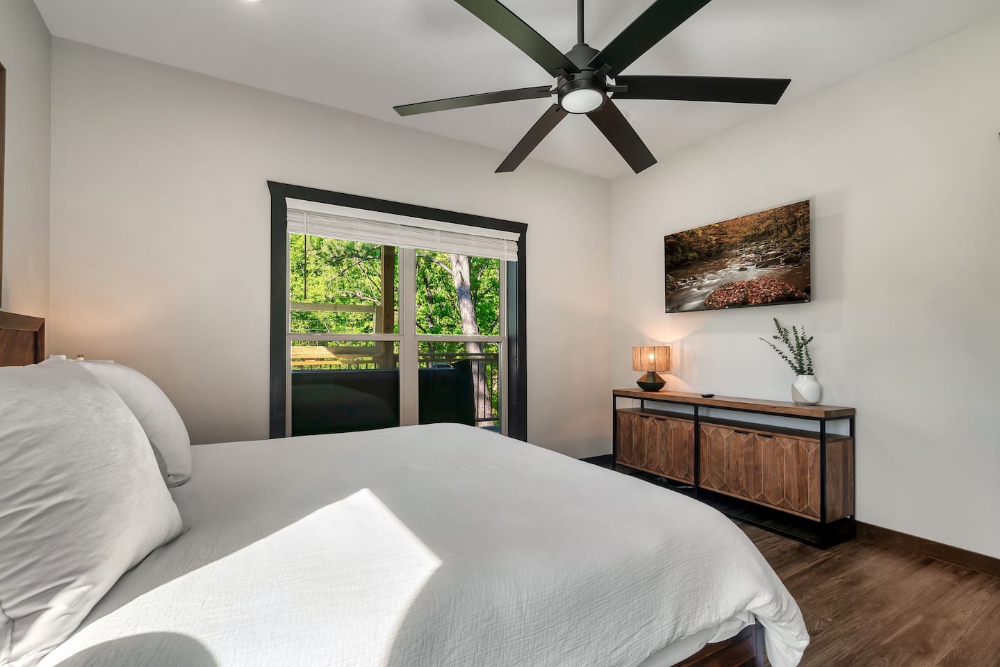 Lower-level king bedroom with balcony access and Smart TV.