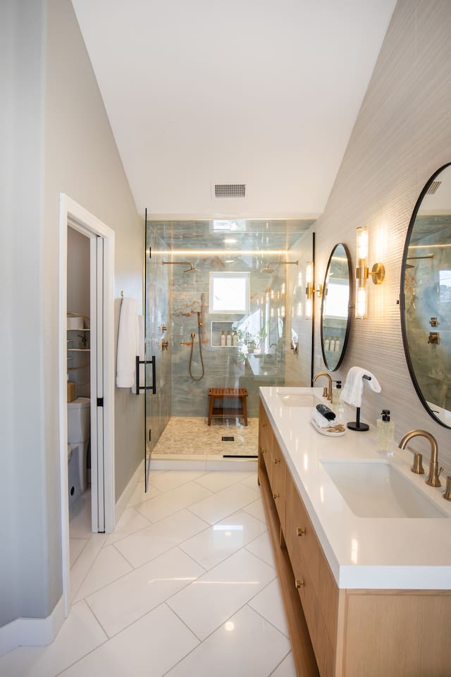 Refresh together in the custom two-person shower, featuring dual shower heads for a spacious, luxurious, and personalized experience.