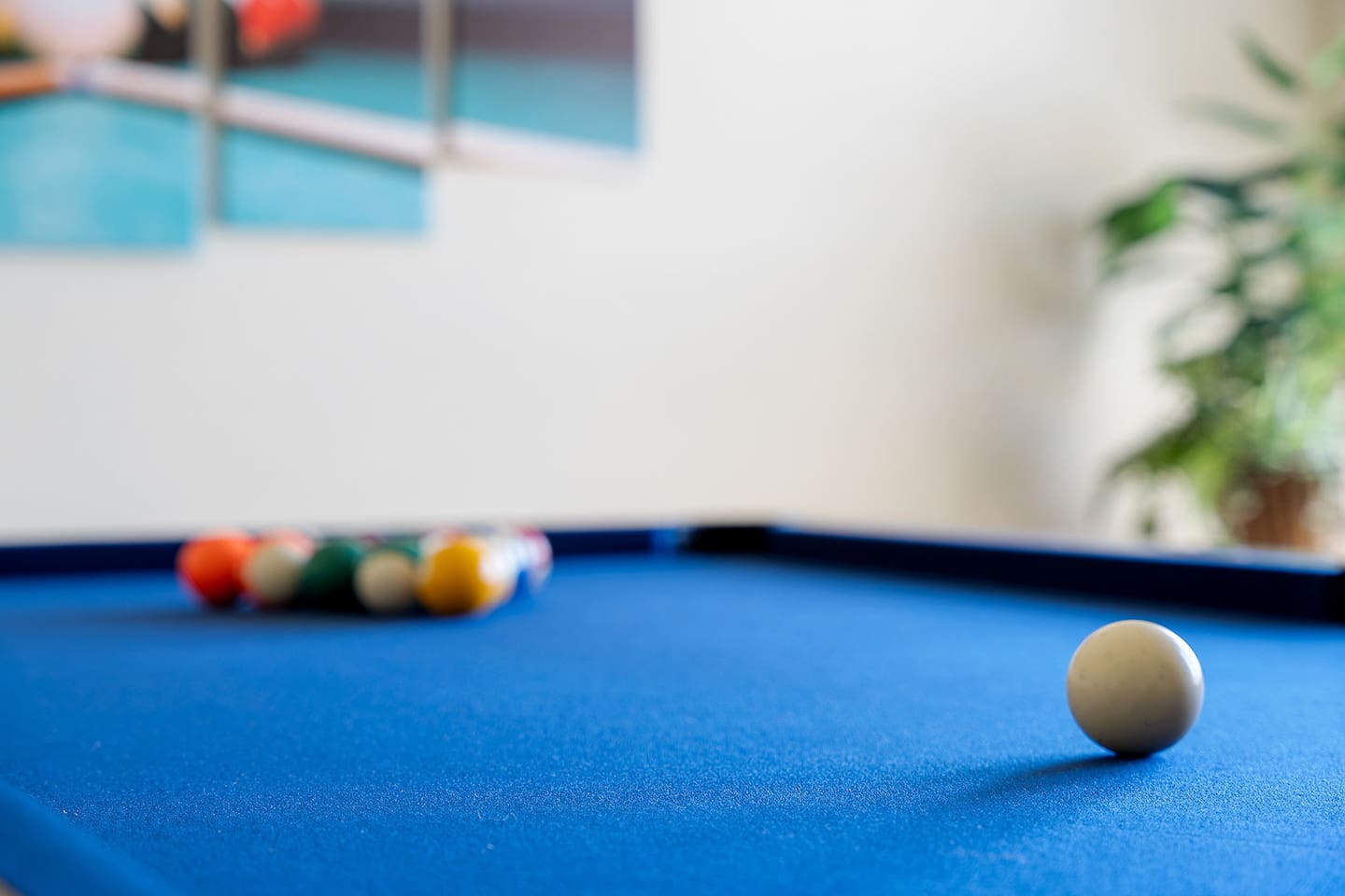 Delight in a game room featuring a pristine pool table and vibrant wall art.