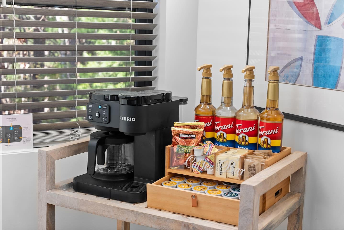 Coffee bar stocked with Torani syrups, organic K-cups, ground coffee, sugar and cream