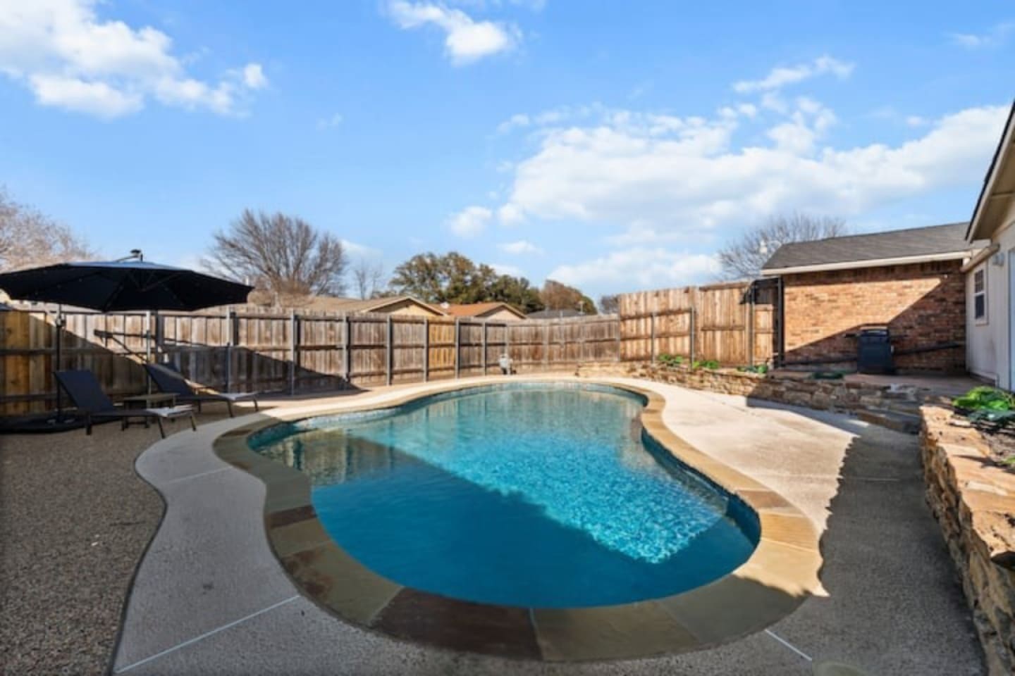 Private backyard oasis with sparkling pool, sun loungers, and direct access to the indoor bar—perfect for poolside entertaining.