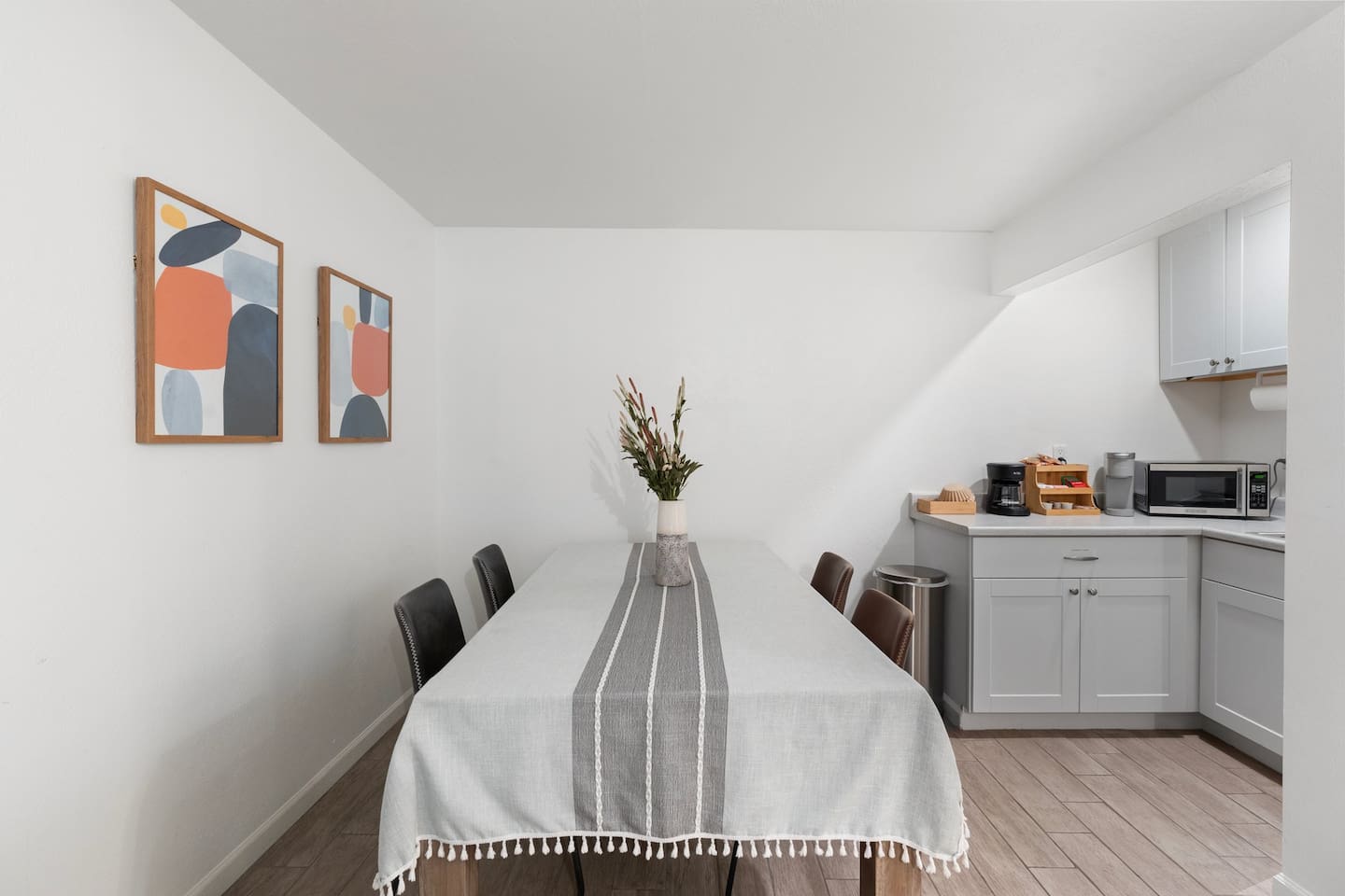 Set beside a fully stocked kitchenette, this table offers convenience and charm for snacks, drinks, or relaxed dining.


