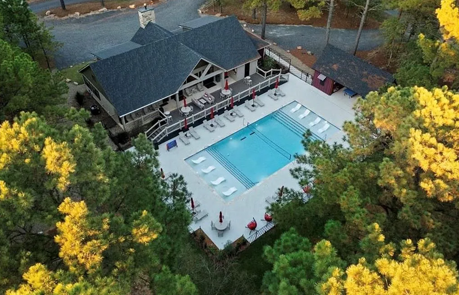 Aerial view of the community pool surrounded by beautiful forest scenery