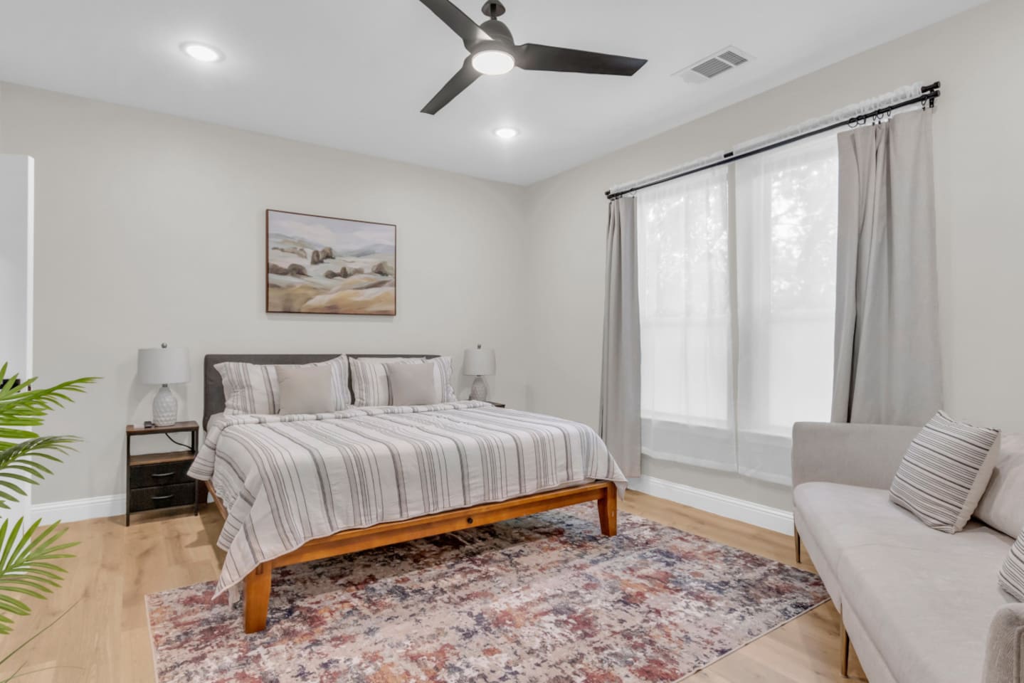 Cozy bedroom with king bed, room darkening shades, and soft neutral tones.