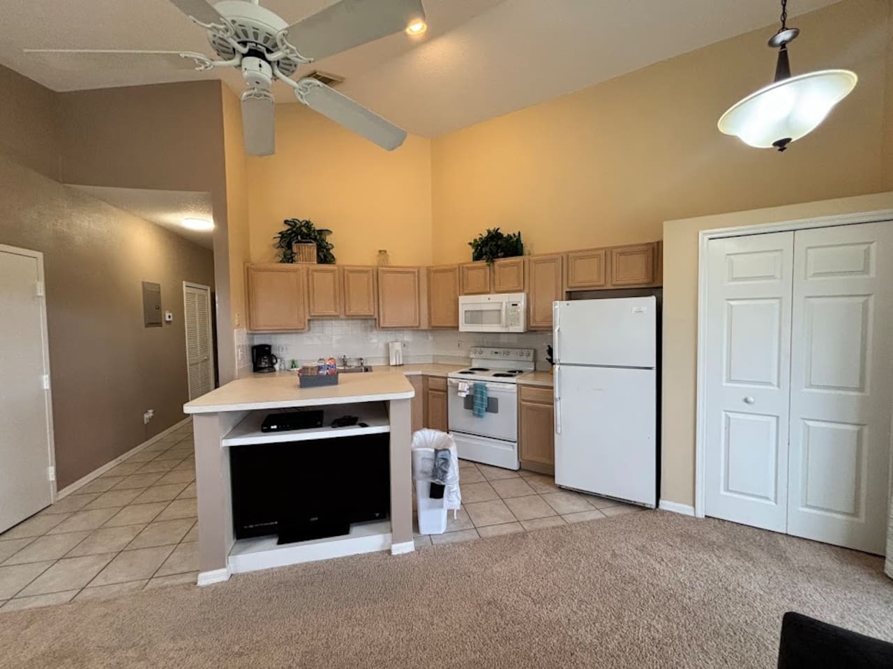 Open kitchen area with breakfast bar seating, full-size appliances, tile flooring, and easy access to the dining and living areas.