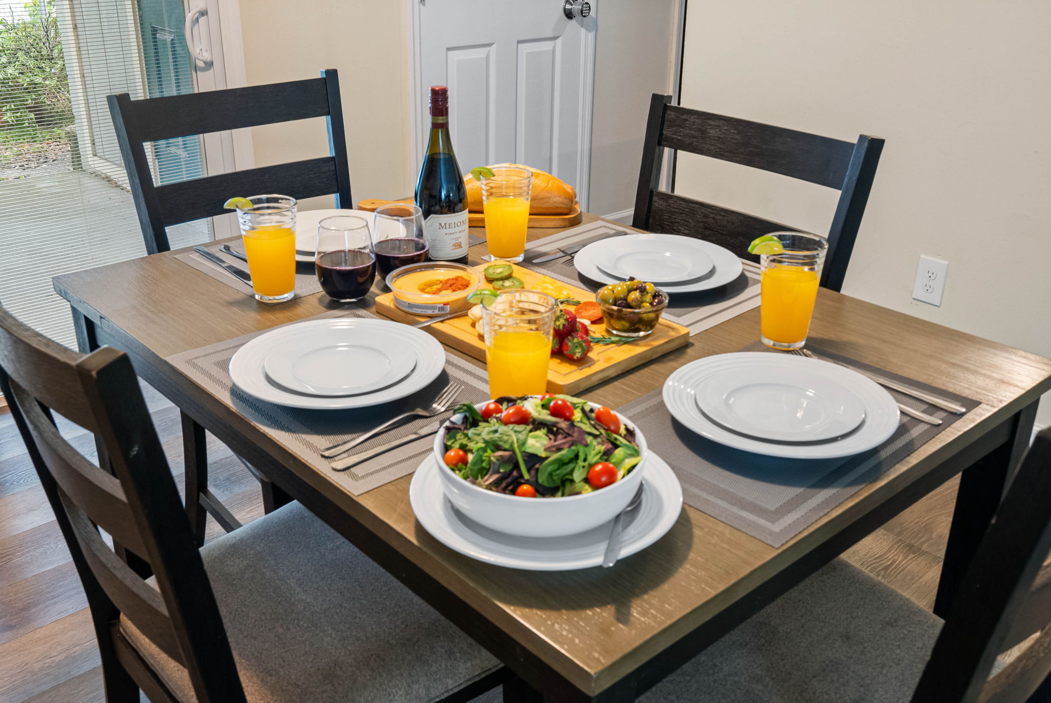 The dark wood table and sleek chairs with soft gray cushions offers a modern yet cozy vibe. 
