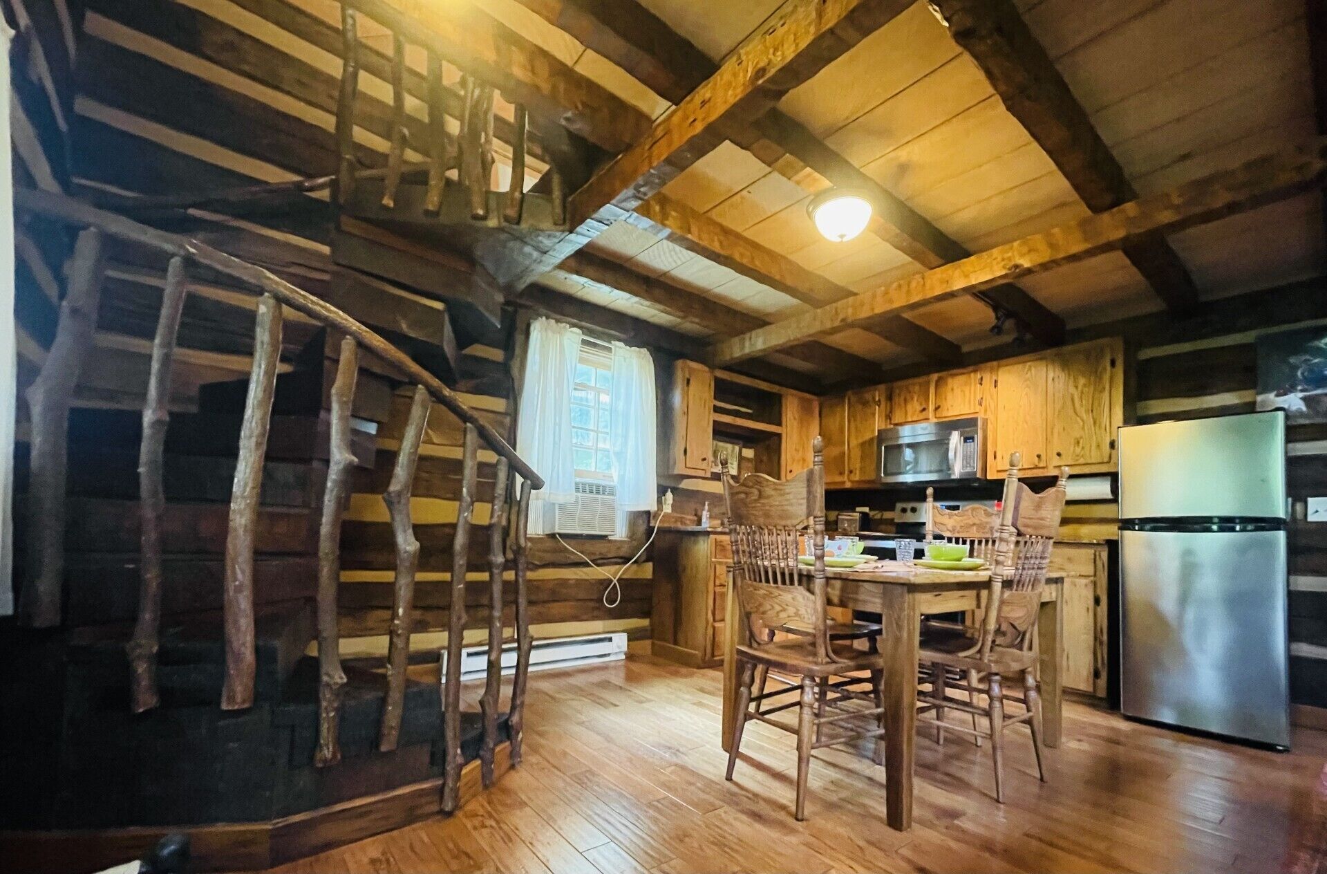Dining for 4 that is open to the living room. Hand hewn spiral steps to loft.