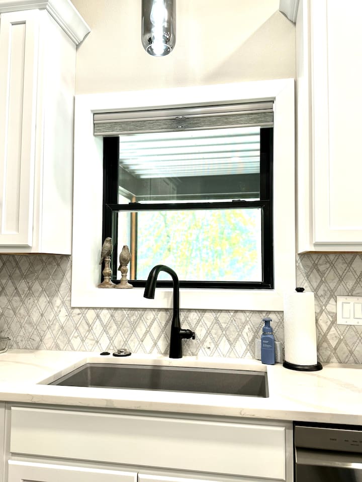Large sink, garbage disposal, dishwasher, and more. Window peaks into the screened-in porch over looking the back yard.