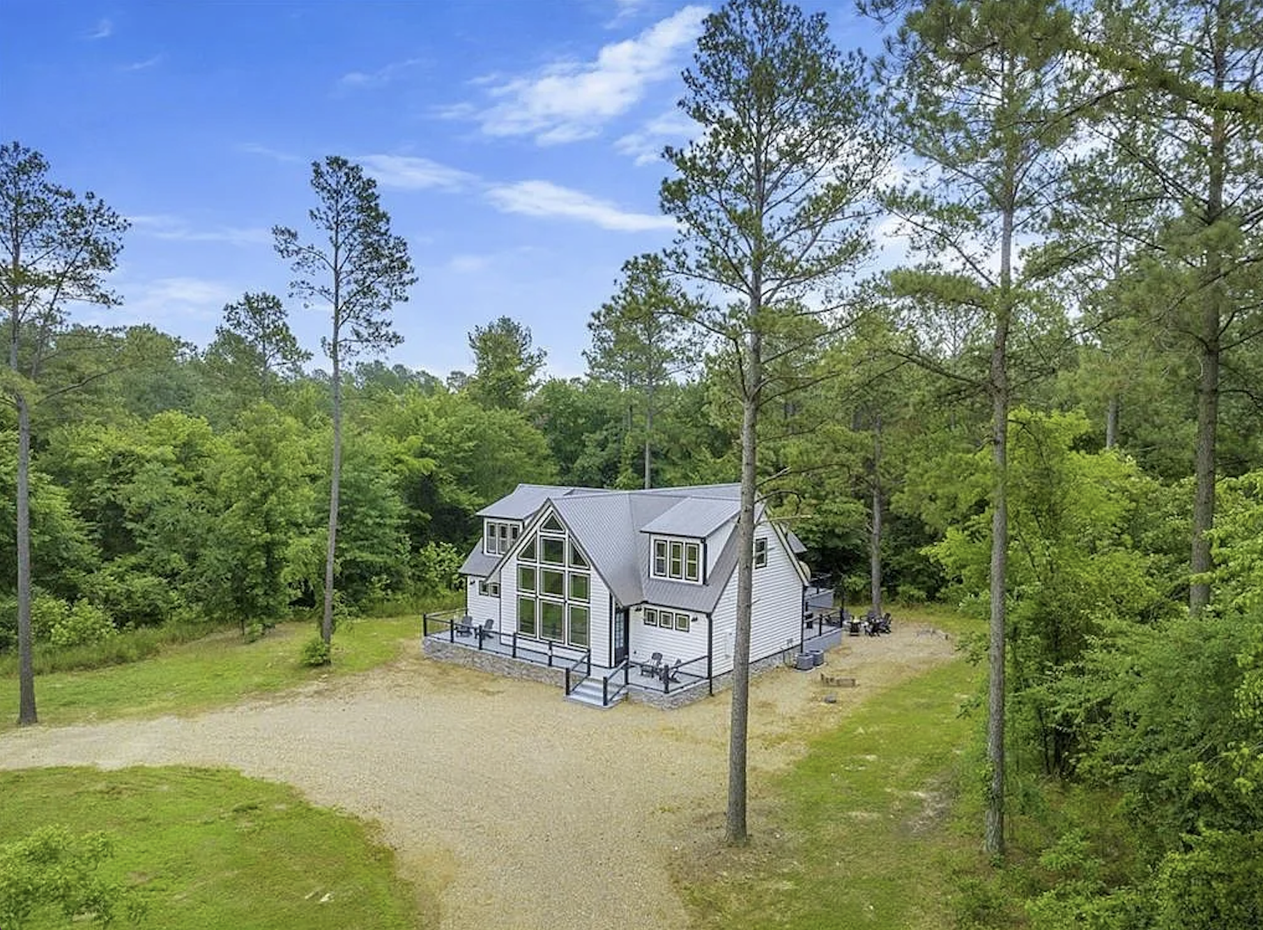 Scenic aerial view of the cabin surrounded by peaceful woodland.