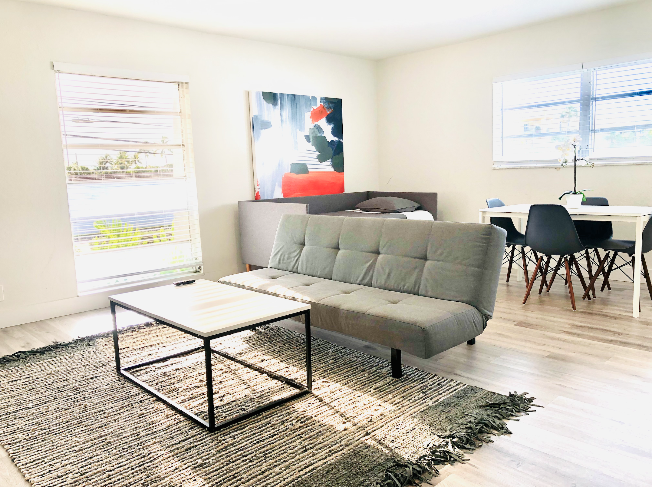 Wide view of living room and dining area. Futon replaced with queen sofa bed that sleeps two guests.