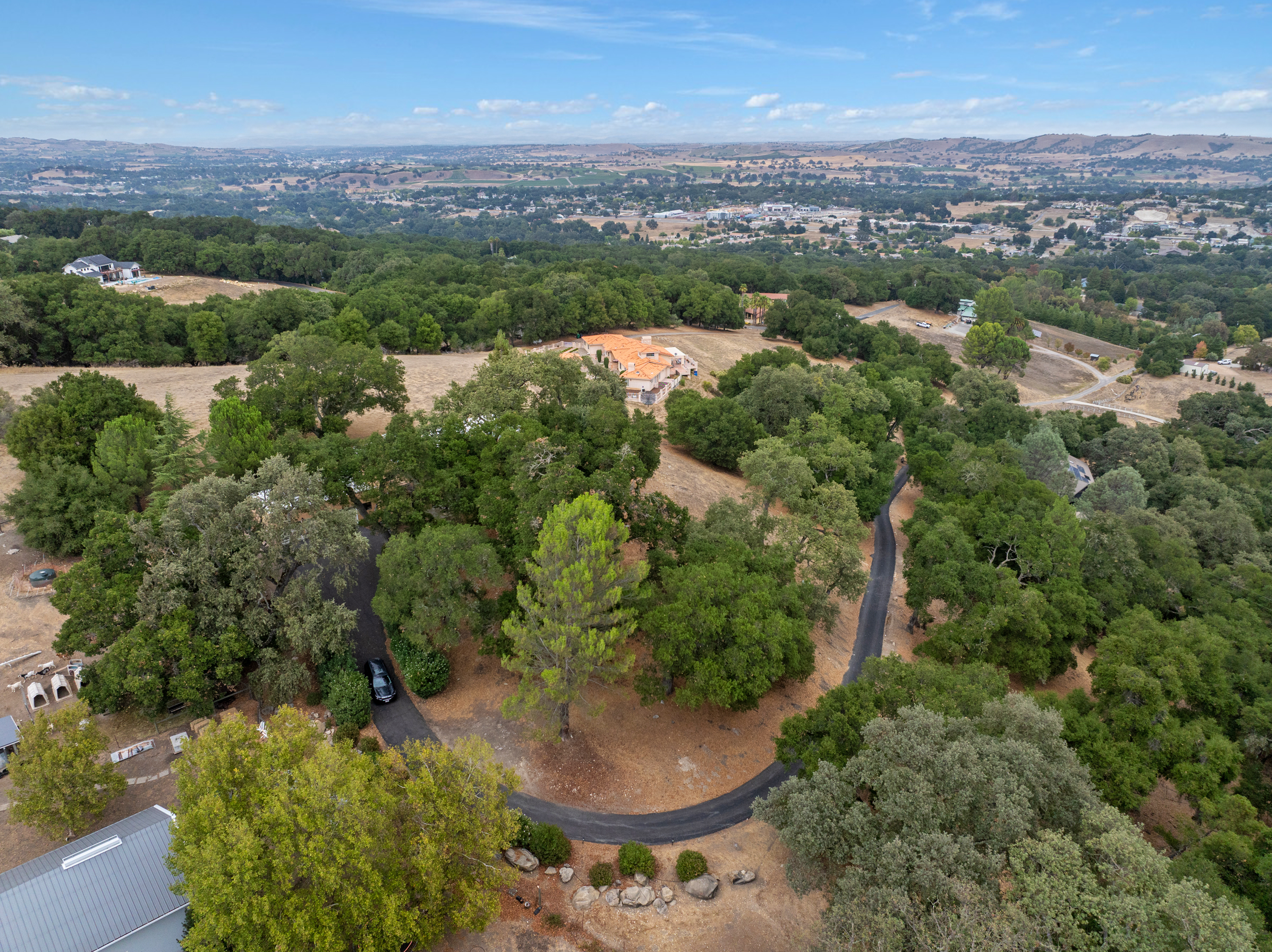 Discover a tranquil hilltop escape, where lush greenery, rolling hills, and a curving country lane set the scene for your stay.