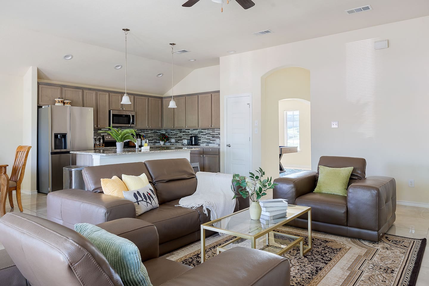 Step into a stylish living room with large leather sofas and a modern coffee table, seamlessly connecting to a sleek kitchen, stocked with the essentials you will need to make a great meal!