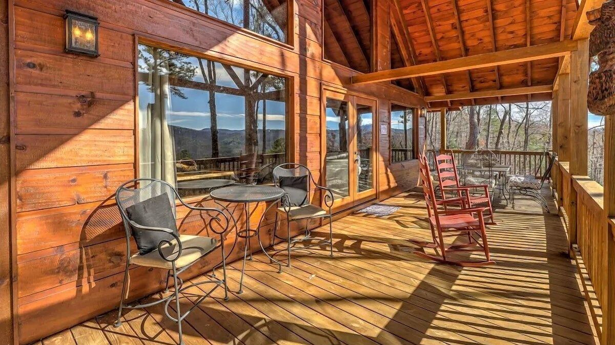Sun-drenched terrace overlooking the mountains, featuring rocking chairs and outdoor seating for relaxing in the fresh mountain air.