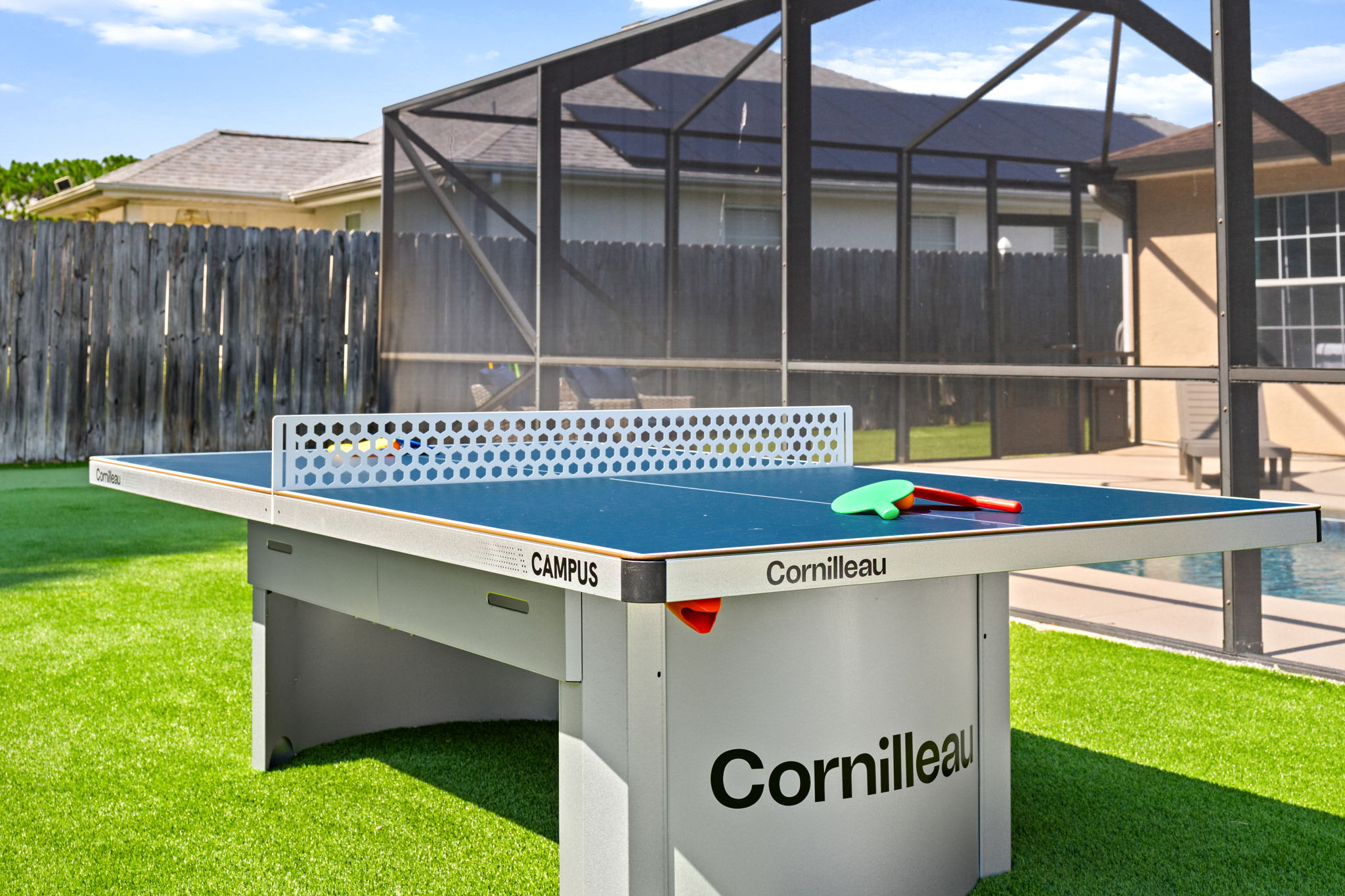 Game on! Our backyard features a premium Cornilleau outdoor ping pong table. Complete with paddles and balls, it's perfectly set up on the turf for quick matches or full group tournaments right by the water.