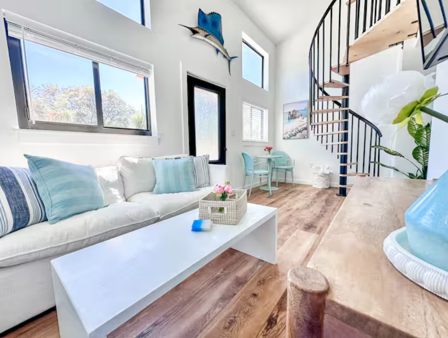 Small Serenity 3's Living Area with a comfortable sofa around a 55" Smart TV, tons of natural light dining space, access to front patio