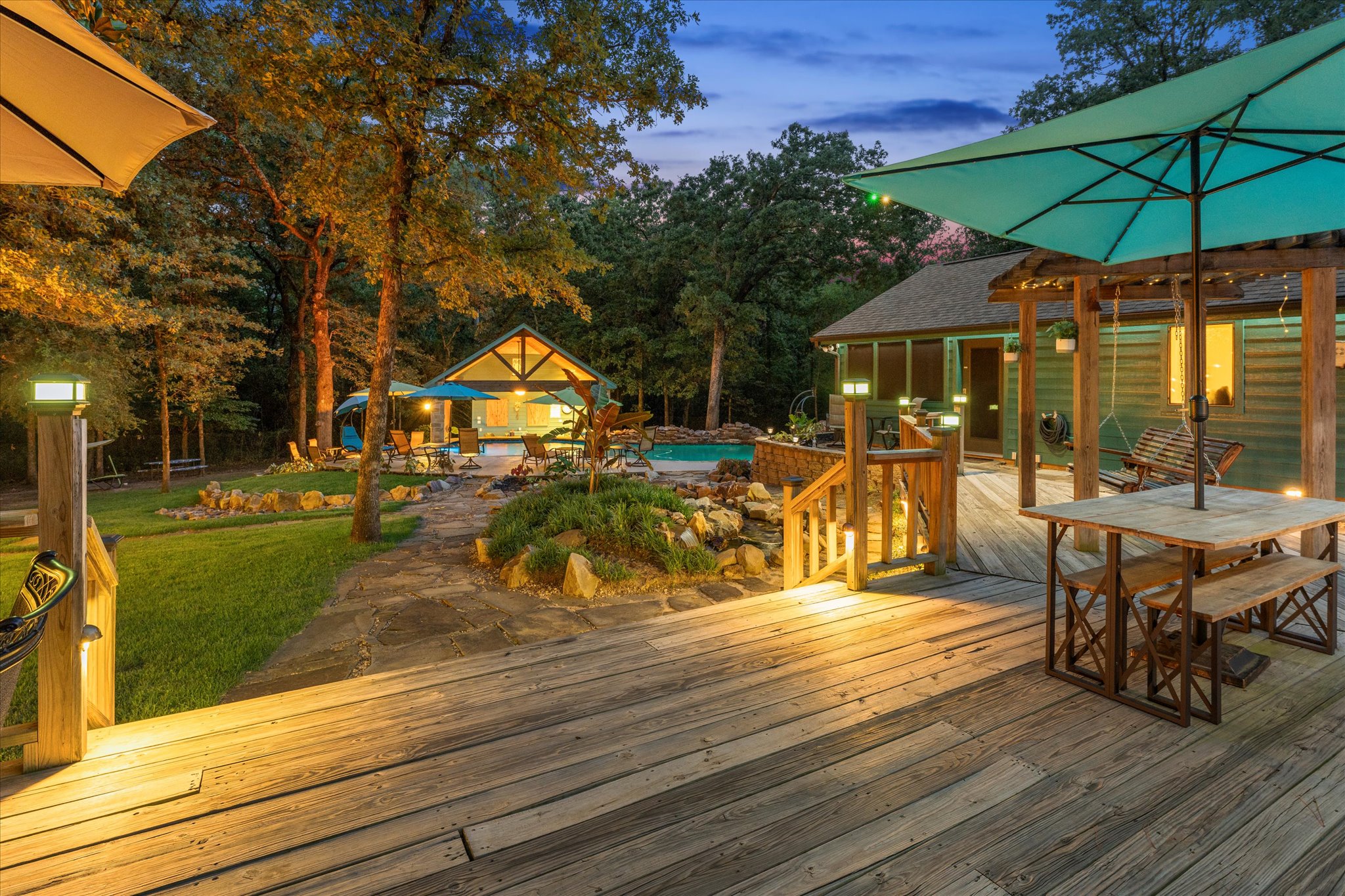 Sitting on the deck at night is pure magic. The soft glow of the exterior lighting creates a perfect balance—bright enough to see, yet dim enough to relax. Enjoy the massive deck's glider rocker, porch swing, hammock, and swivel chairs for ultimate comfort