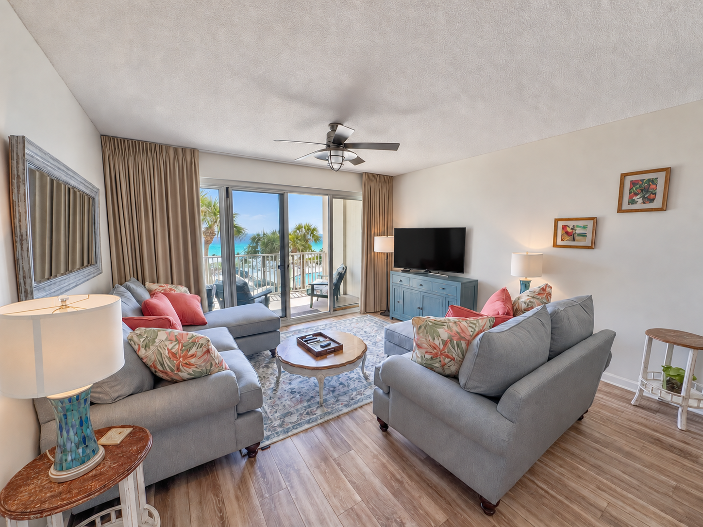 Living room with updated seating, a TV, and direct balcony access with Gulf views.