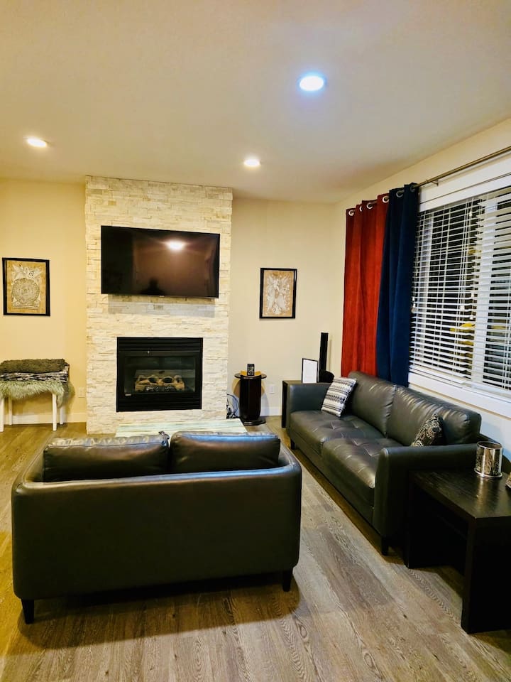 Stylish living room with stone fireplace, leather sofas & smart TV