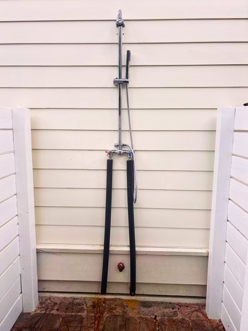 Enjoy an outdoor shower with hot & cold water and a pavered floor.