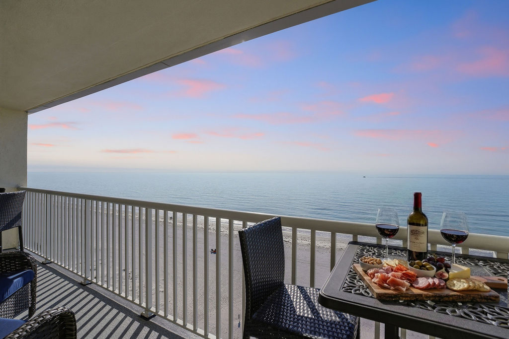 Private oceanfront balcony with breathtaking sunset views, outdoor dining seating, and the perfect space to enjoy wine, coastal breezes, and unforgettable beachfront relaxation.