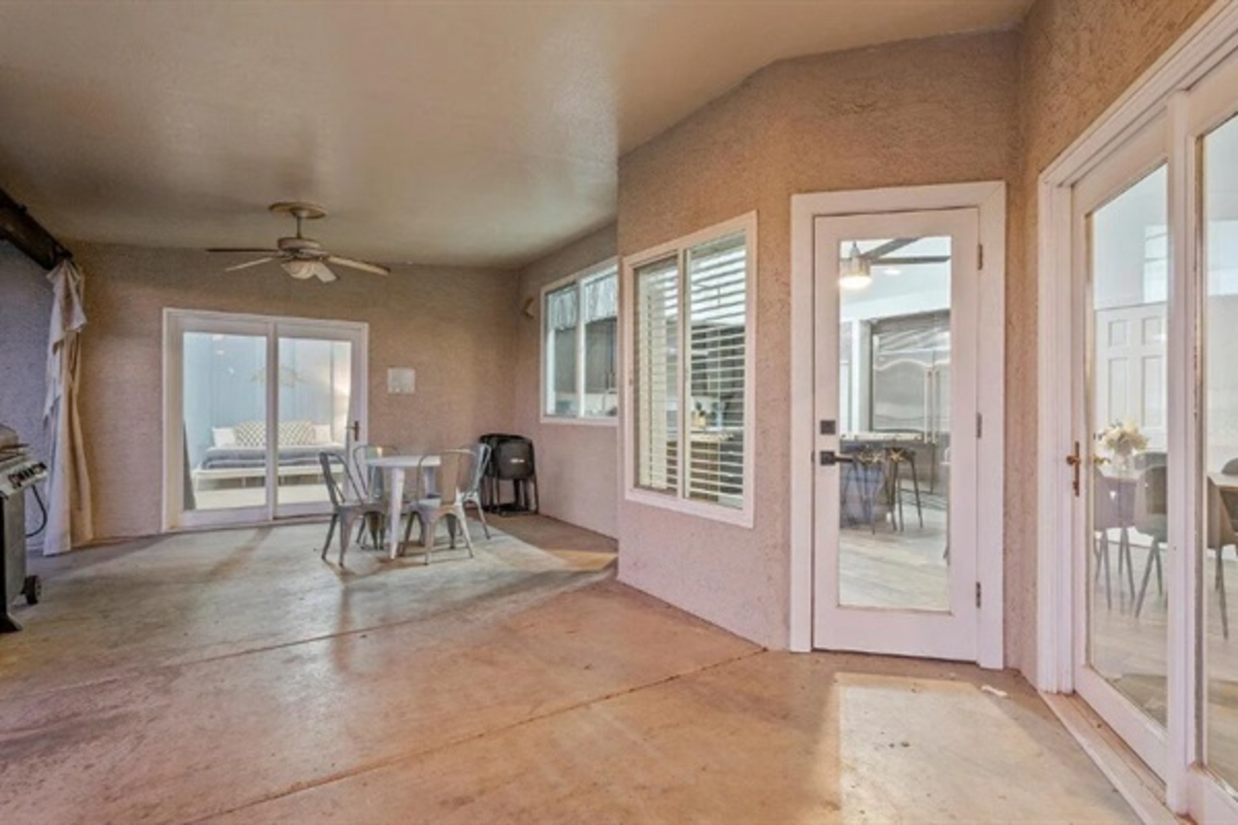 Dine outdoors under the covered patio with ceiling fans and fresh air just steps from the kitchen and pool.