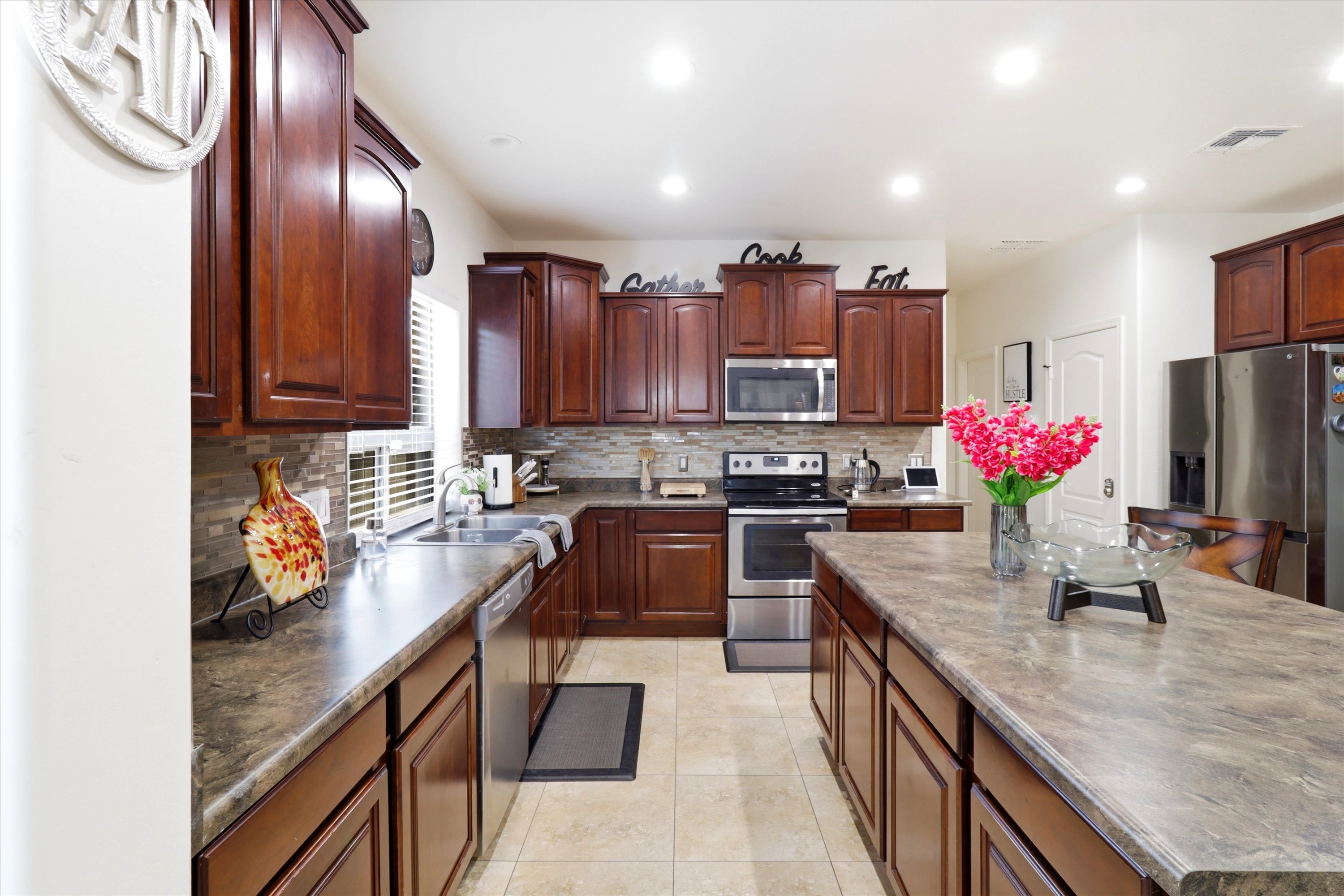 Kitchen with dark wood cabinets, a center island, full appliances, and lots of space for cooking.
