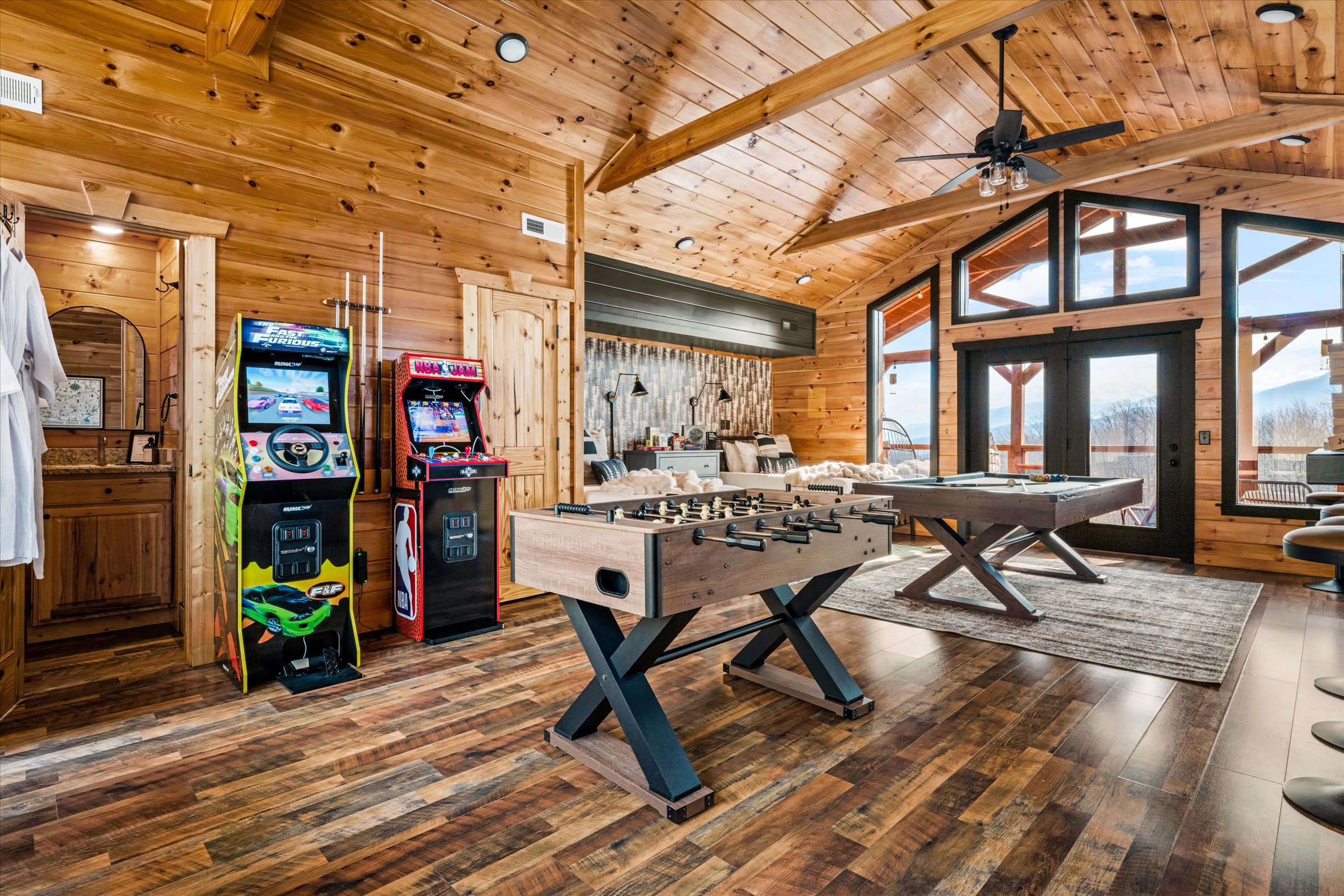 Spacious game room with pool table, foosball, and arcade games with mountain views