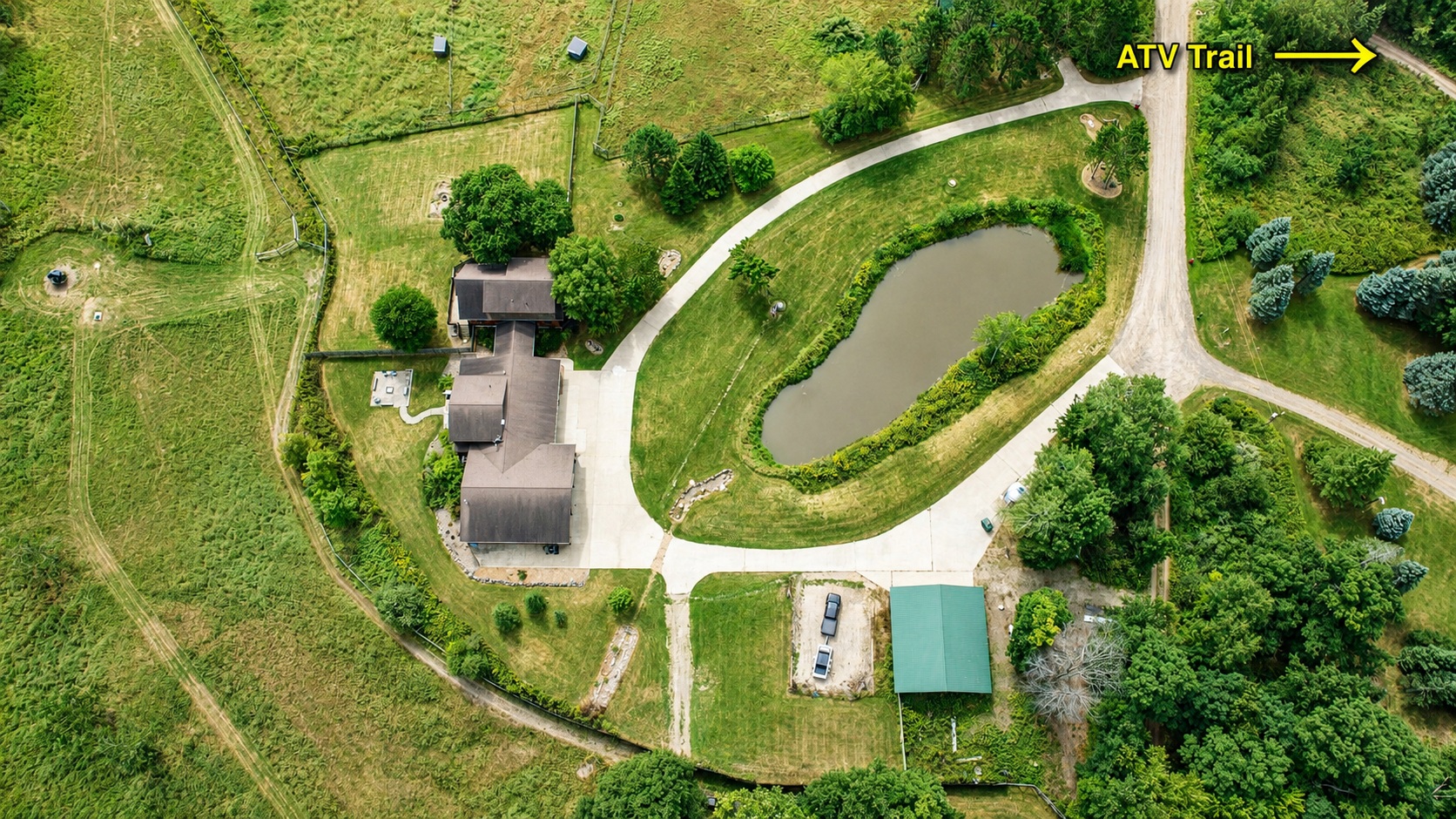 Aerial view of the property with plenty of parking for trucks and trailers and the ATV trail just steps away. Bring your machines, unload with ease, and ride straight from the property for an unforgettable Northwoods adventure.