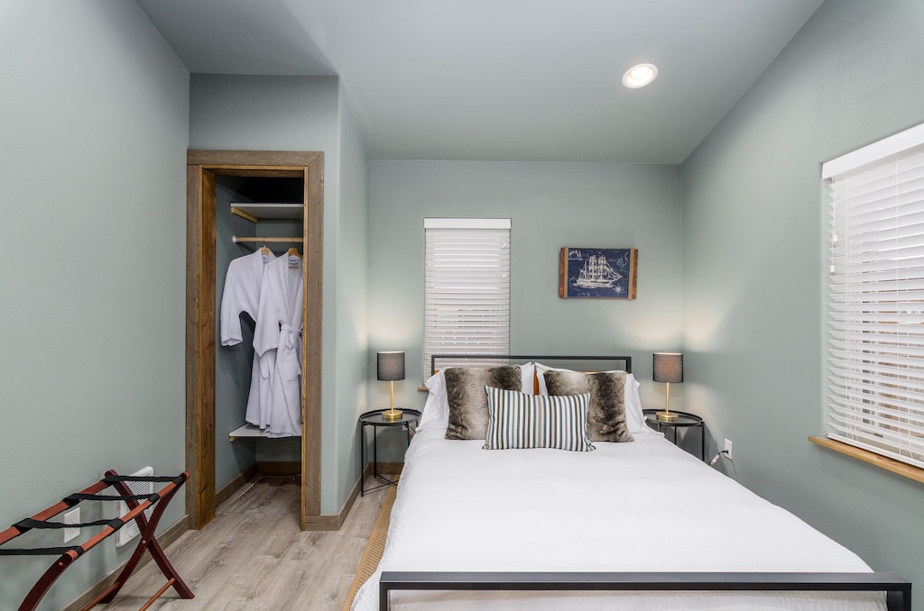 Back bedroom equipped with waffle weave robes, USB lamps, luggage rack, and fan