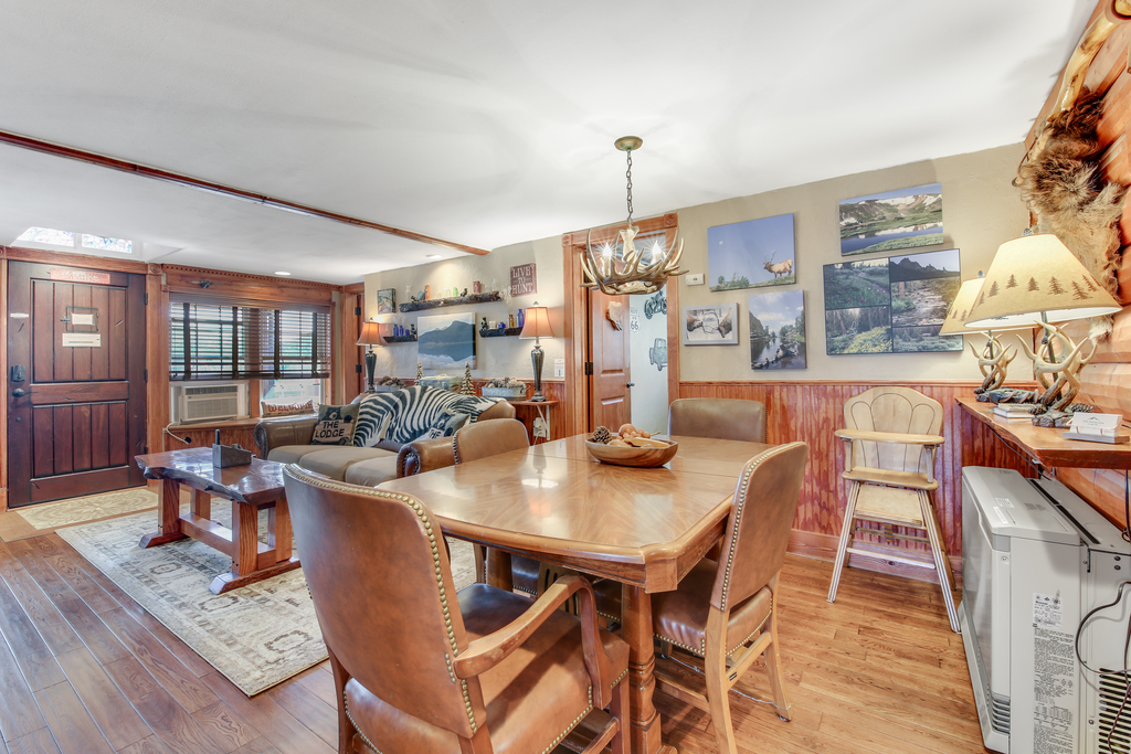 Gather for meals at the rustic dining table beneath the antler chandelier.