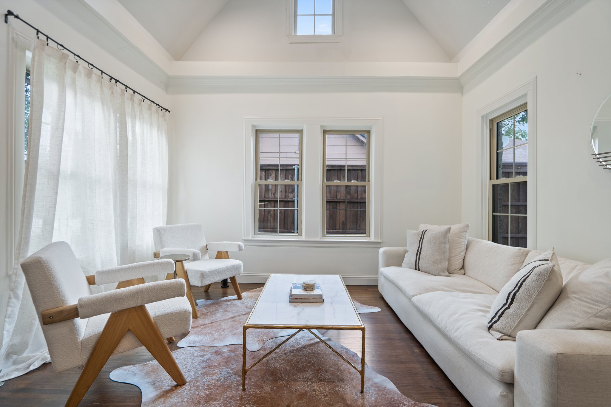 Living room seating area with neutral sofas, coffee table, and oversized windows. 55-inch Smart TV, high-speed Wi-Fi, central AC and heat, and portable fans. Comfortable open layout for groups.