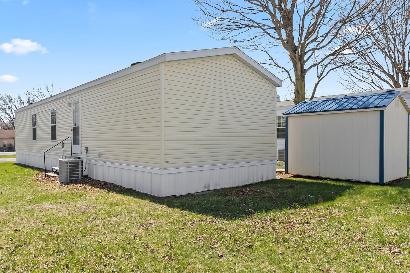 Full exterior perspective showing the home, yard in a quiet residential setting.