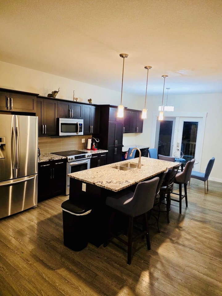 Modern kitchen w/ granite island, stainless appliances, dining nook