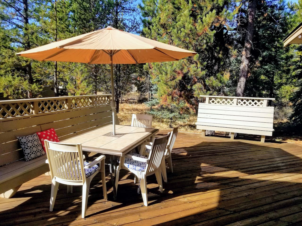 The deck also has plenty of seating for all with a full-length bench, and the view highlights  the perks of a quarter acre lot!  A bike path is located out past the trees a ways. 