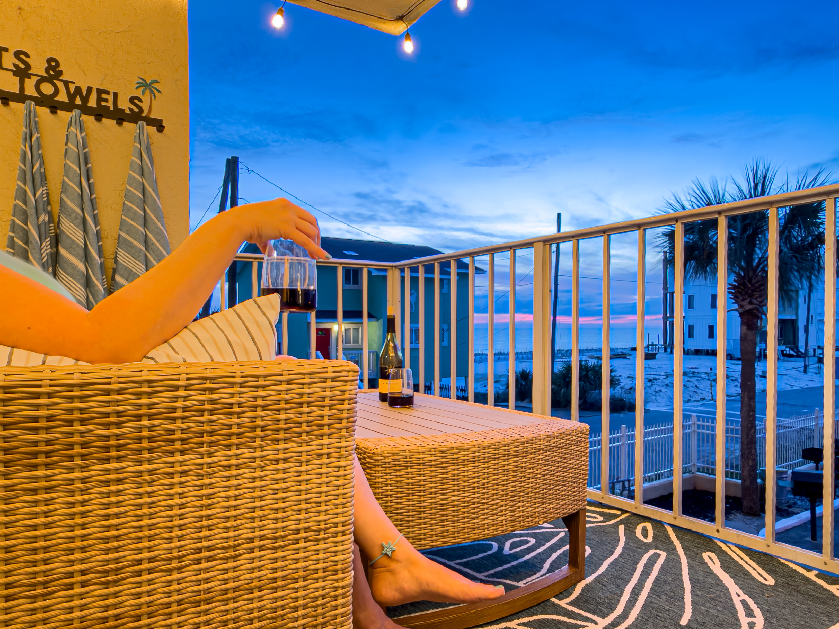 You can hear the ocean from the deck while you enjoy a quiet evening. The overhead string lights create a cozy space for your evening drinks.