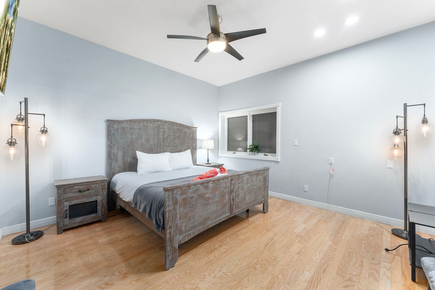 Spacious retreat with a king-size bed, modern ceiling fan, and flat-screen TV for your entertainment