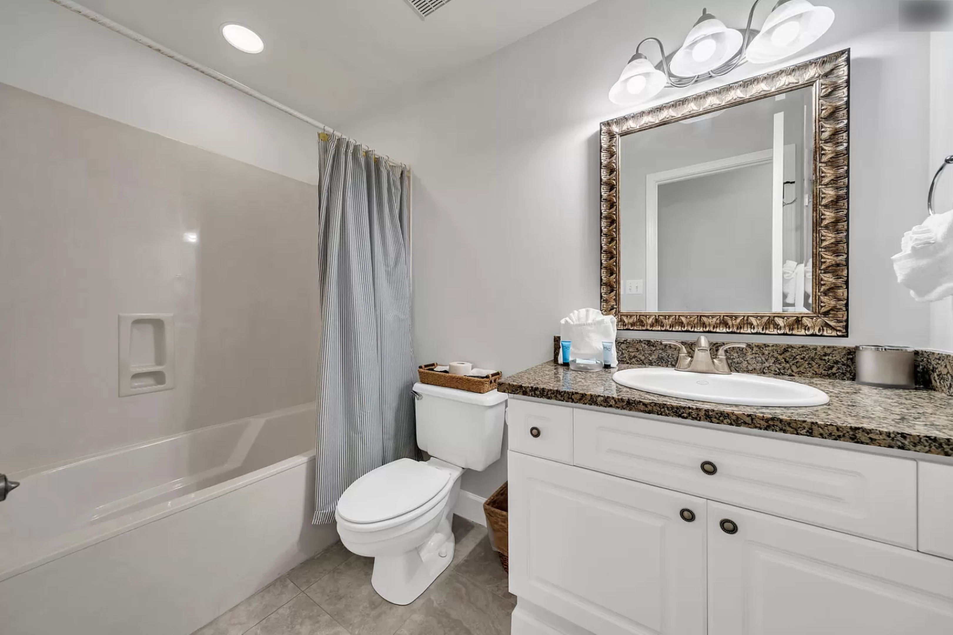 Modern and bright bathroom. Includes a tiled bath/shower.