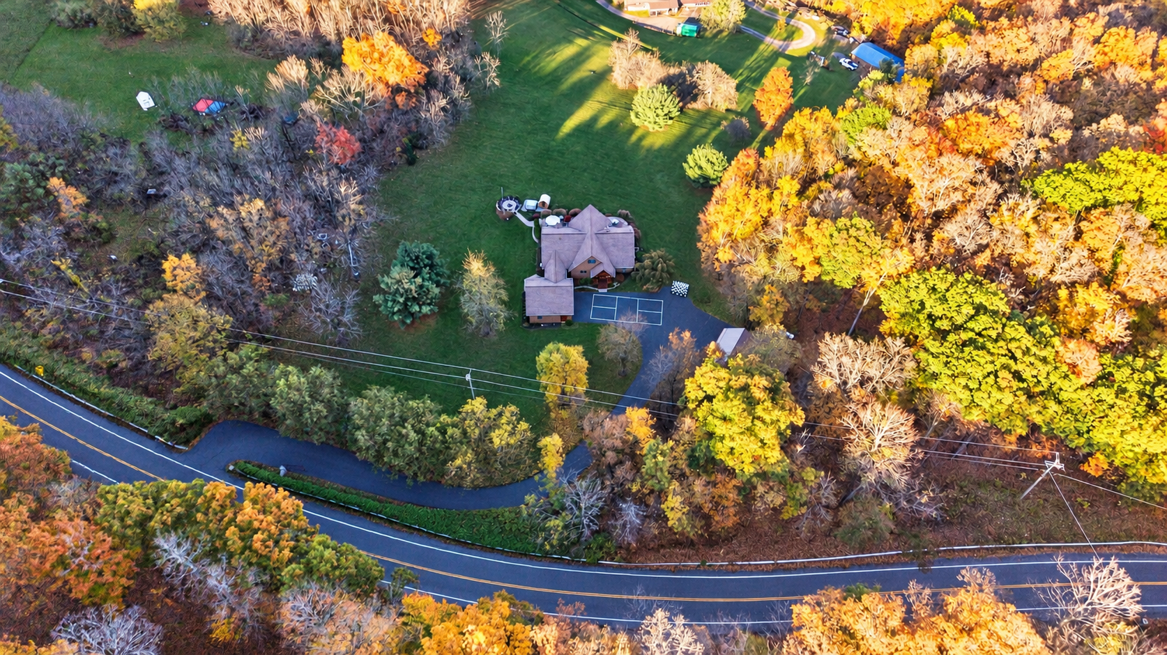 Aerial view of property beside tree-lined road