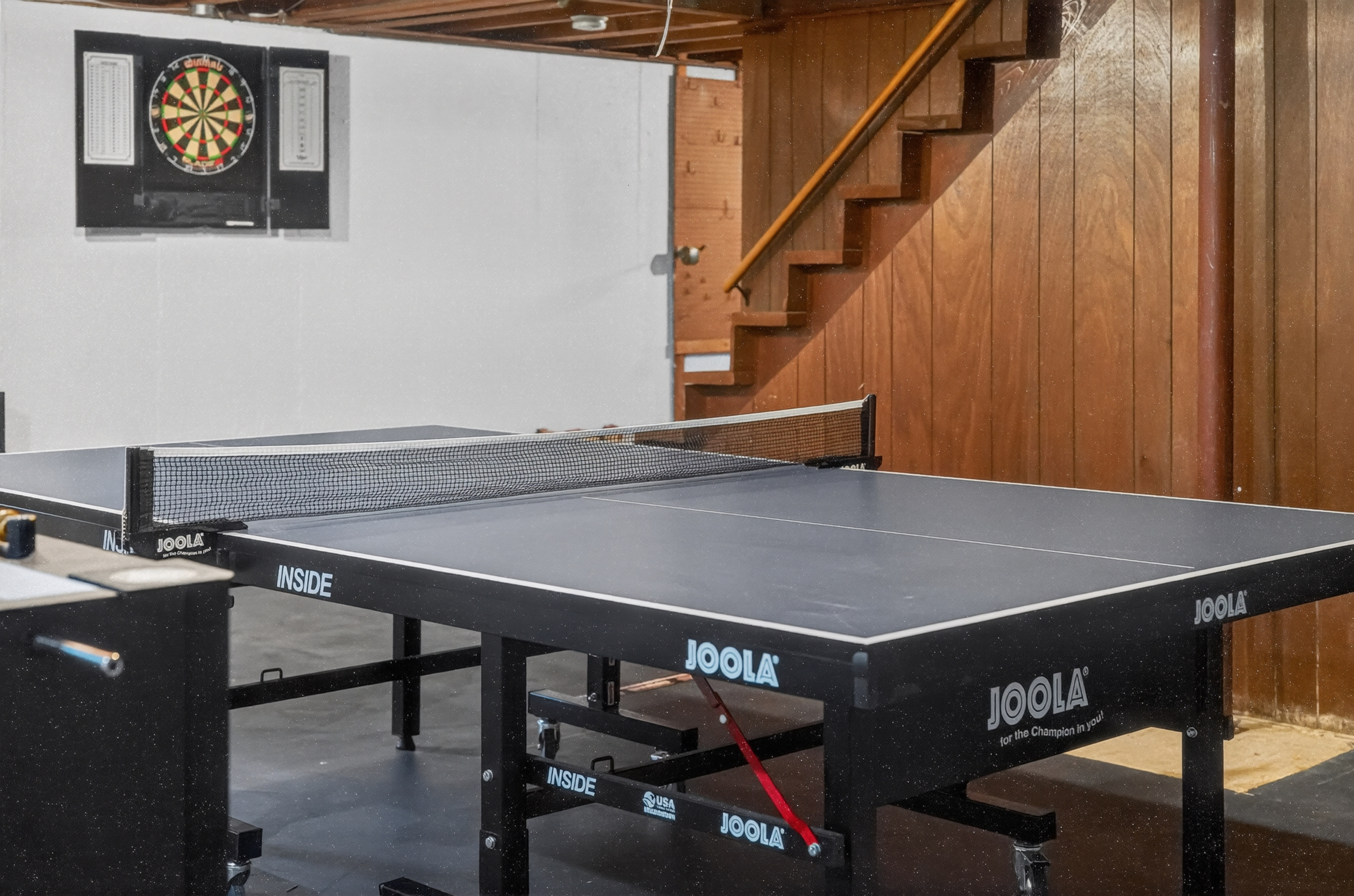 A fun-filled basement game area with ping pong, darts, and foosball for everyone to enjoy!