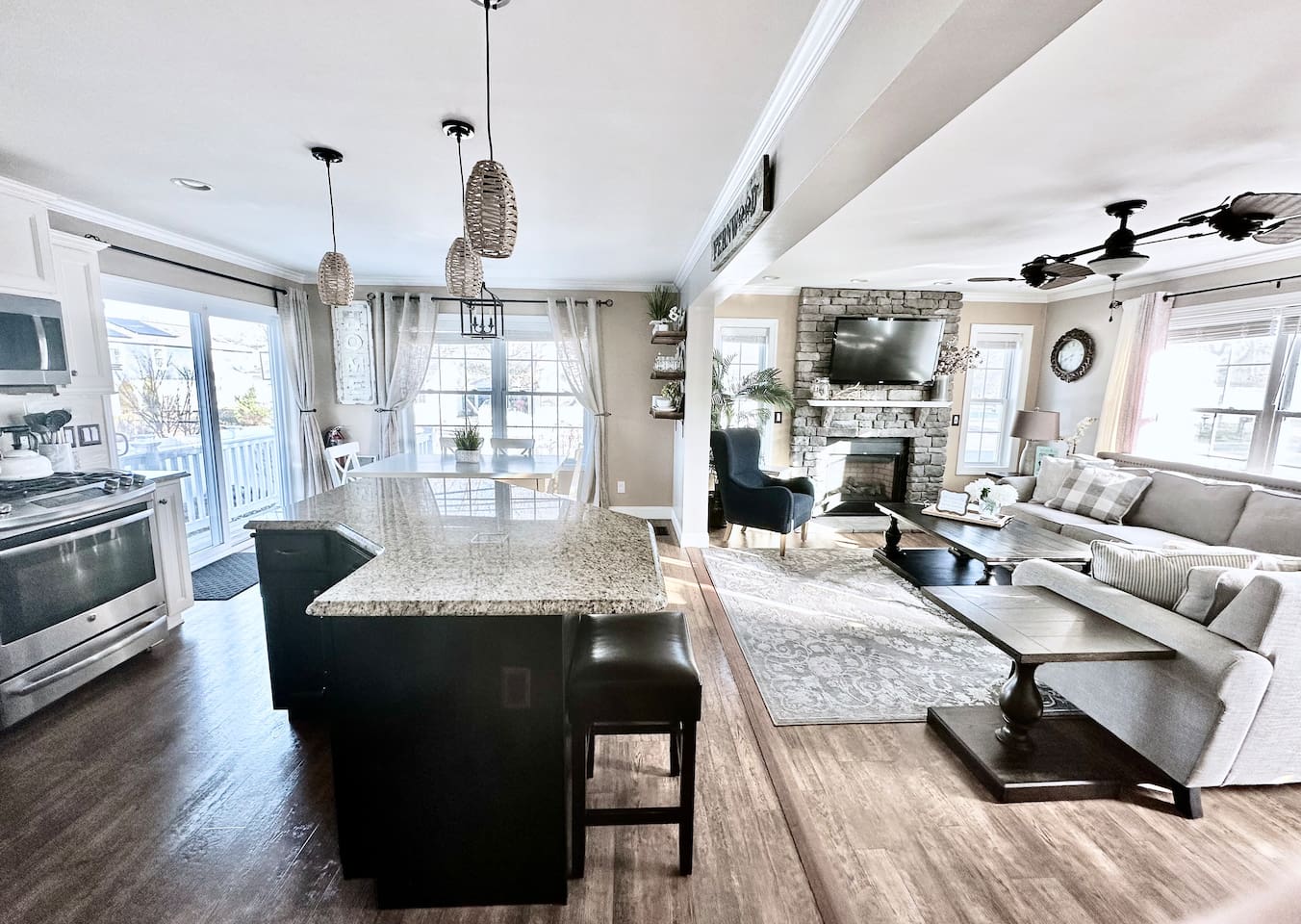 Experience the best of open-concept living in this bright, airy space. Guests can easily move from the modern kitchen with its large granite island to the cozy living room, making it the perfect hub for socializing and shared meals.