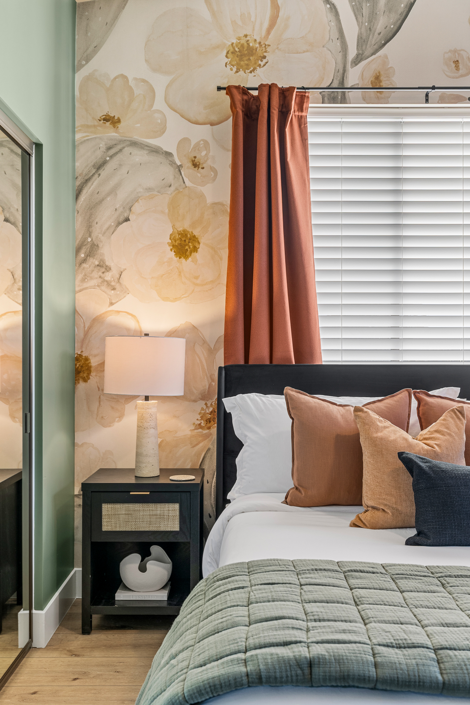 Soft bedding, warm lighting, and layered textures create a comfortable space designed for restful sleep.