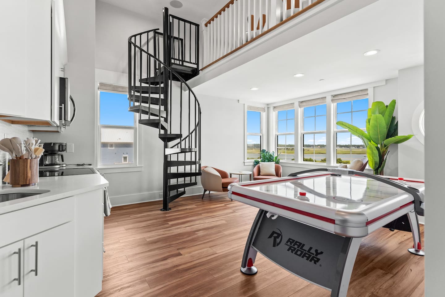 The game room features air hockey, NBA Jam arcade game, a smart TV, & a full kitchen for snacks and drinks. A loft w/spiral staircase overlooking the space adds even more flexibility with 1 full + 2 twin beds-perfect for kids, teens, or extra guests.