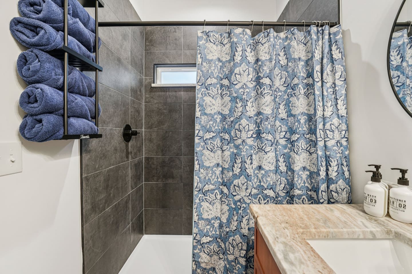 Primary bathroom has double vanity, large walk-in shower, body wash, shampoo, conditioner, plenty of towels, hair dryer, and first aid kit