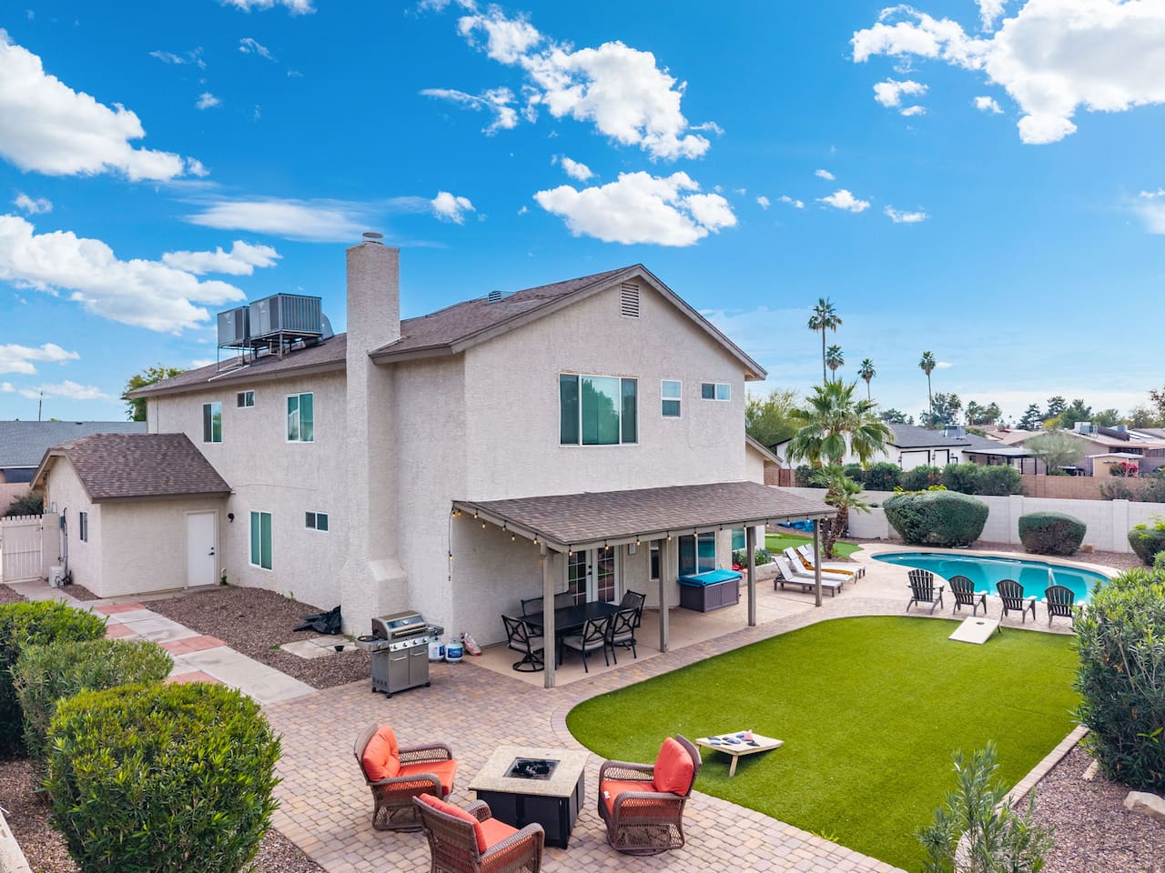 Backyard oasis with pool, covered patio, firepit, and manicured lawn—perfect for relaxation and gatherings.