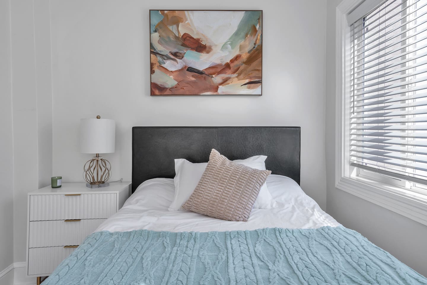 Sweet dreams in our cozy full-size bedroom—modern art, soft linens, and gentle morning light