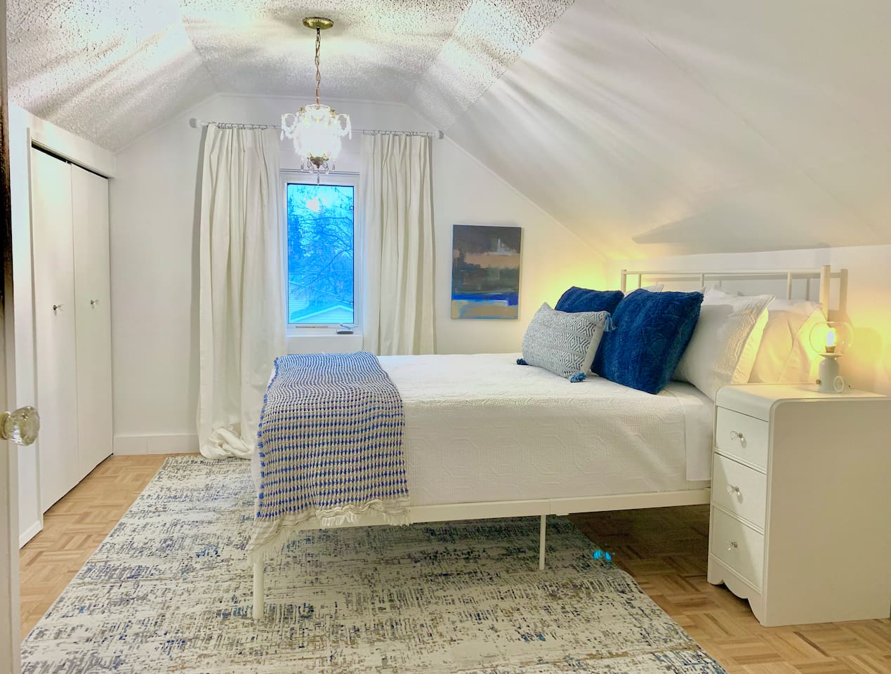 Primary bedroom located upstairs with queen bed, quality linens, and window coverings for a restful sleep.